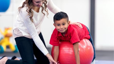 Therapist provides pediatric rehabilitation services to child.