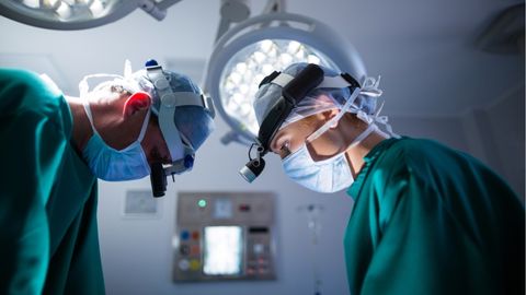 Expert cancer surgeons performing surgery on cancer patient.