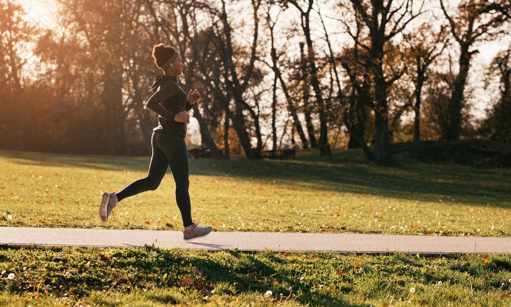 Women running outdoors on fall day revitalizes her health routine.